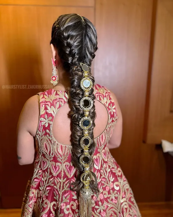 This is a statement bridal braid, perfect for a Sangeet or the wedding day. I've used intricate weaving techniques and adorned it with bold, oversized mirror accessories for a truly unforgettable look.