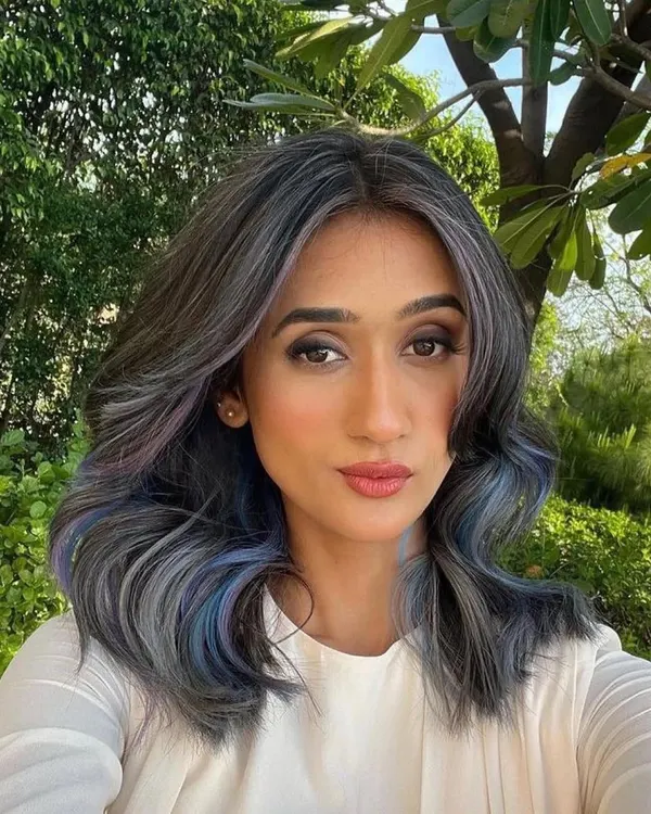 This is a beautiful blend of ash, lilac, and blue shades. The cool tones work together to create a unique and modern look, with face-framing pieces that highlight the client's features.