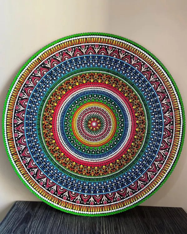 This is a full view of my 24-inch dot mandala, a piece I poured my heart into. Created on a circular MDF board, the intricate patterns and vibrant colors are designed to be a captivating centerpiece for your wall. This artwork is available for purchase.