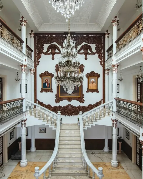 A breathtaking view of the triple-height living area in our "Palace Promised" project. The grand bifurcated staircase, crafted from pristine white marble, and the magnificent crystal chandelier embody the royal elegance and architectural precision we bring to every home.