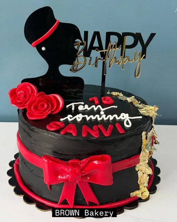 A chic cake for a teenager. This pure chocolate truffle cake features a stylish silhouette topper, a red fondant bow, and a touch of gold leaf for a sophisticated look. We only use fondant for decorations, never for taste.