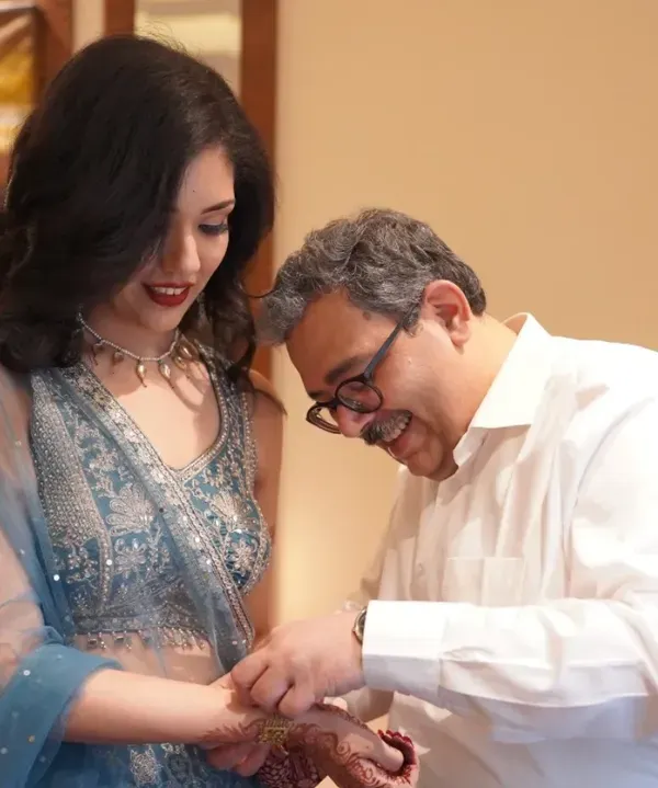 A father's gentle touch as he helps his daughter with her jewelry. These quiet, behind-the-scenes moments are often the most precious.