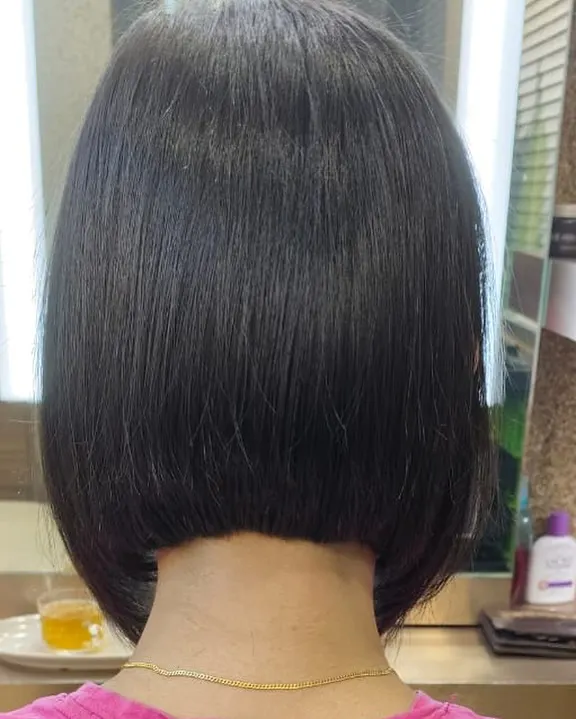 A perfect example of a classic, sharp bob haircut. The precision in the cut creates a clean, strong line, resulting in a timeless and sophisticated style that is effortlessly chic.