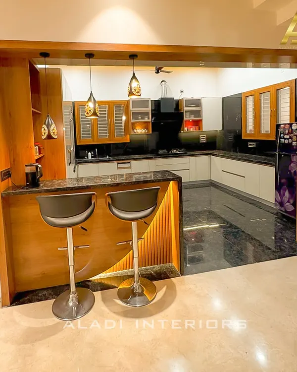 This open-plan kitchen features a custom breakfast bar with integrated lighting and wood paneling, seamlessly connecting to the main kitchen area.