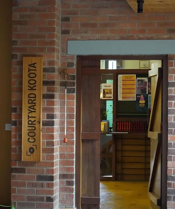 The entrance to our performance space. The wooden sign and exposed brick wall welcome you into our intimate black box theatre, a space designed for stories and connections.