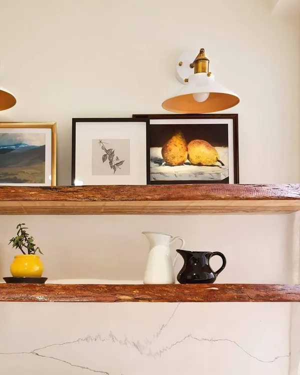 Even utility spaces can have beautiful details. For this area in the 'Breeze Home', I used live-edge wood for the open shelves, adding a rustic and organic touch. The shelves are styled with art and ceramics to make the space feel special.