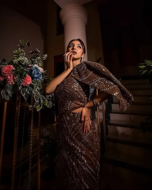 Bold moves only. This look is for the bride who isn't afraid to stand out. The dark, shimmering gown is paired with a sleek hairstyle and confident makeup.