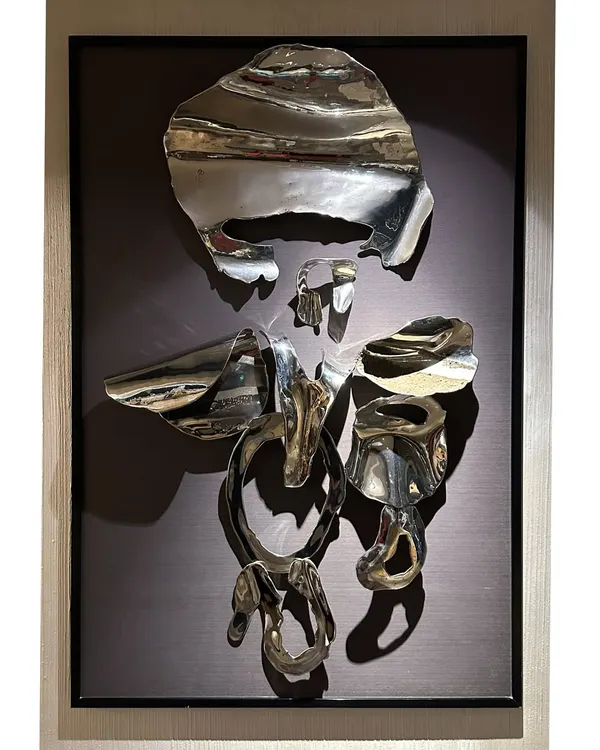 An abstract Ganpati crafted from fragments of polished stainless steel, mounted in a frame. This piece symbolizes strength, resilience, and new beginnings, deconstructing the form to its essential spiritual energy.