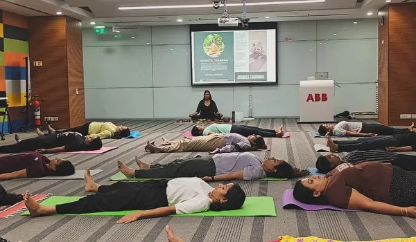 Guiding employees at ABB through Savasana, or corpse pose, at the end of a corporate yoga session. This final relaxation is crucial for integrating the practice and reducing stress.
