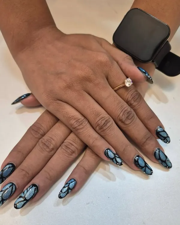 I consider this detailed design a piece of wearable art. Using multiple shades of blue and black, I hand-painted this pattern on long extensions to create a look that is both elegant and bold. This is for the client who wants their nails to be a conversation starter.