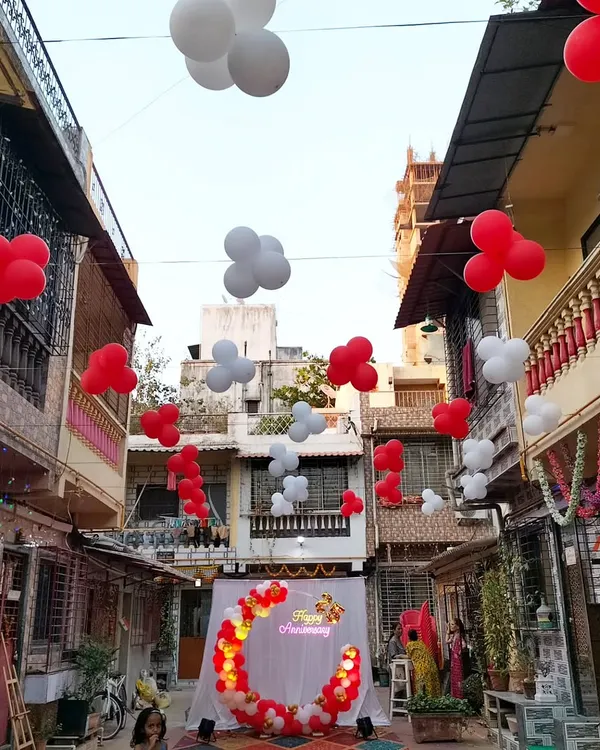 A stunning outdoor 25th anniversary celebration setup in a residential street. We created a beautiful balloon ring backdrop and decorated the entire lane with floating balloon bunches.