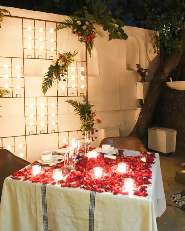 A table for two, set with a wall of candles and scattered rose petals. This is a space I prepare for those looking for a truly private and romantic dining experience.