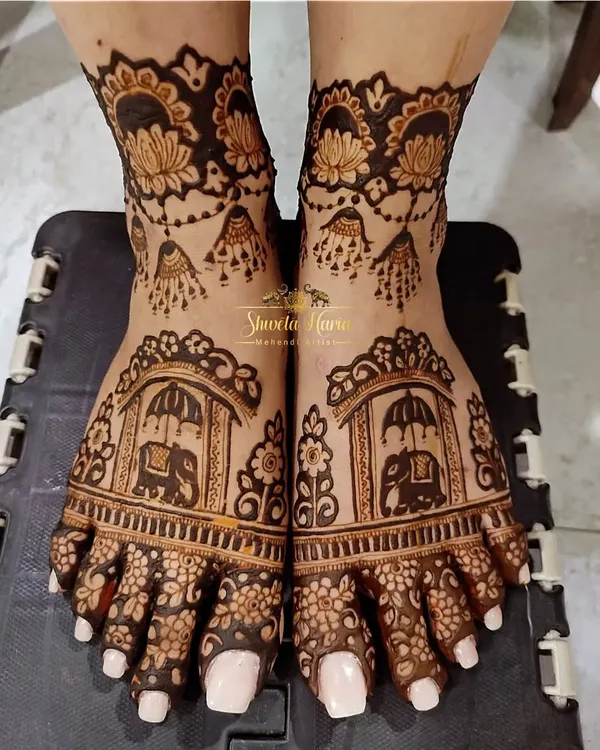 This intricate foot design features majestic elephants within ornate arches, surrounded by delicate floral patterns and hanging jhumka motifs.