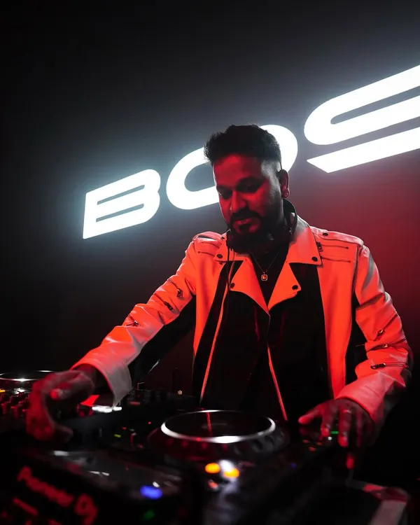 A powerful shot of me mixing under the stage lights with my name in the background. This captures the professional and branded experience I deliver.