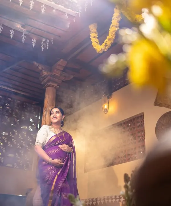 A truly magical maternity shot. The rays of light streaming from above and the soft smoke create a divine, ethereal atmosphere, celebrating the miracle of new life.