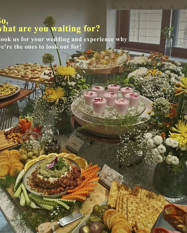 A beautiful grazing table set for a wedding celebration, featuring a variety of our gourmet offerings. This spread includes everything from savory tarts and dips to fresh fruit and floral decor, showcasing our expertise in wedding catering.