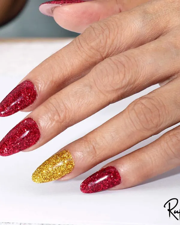 A beautiful before-and-after of a client's nails, transformed with glittery red and gold gel polish on elegant almond-shaped extensions.