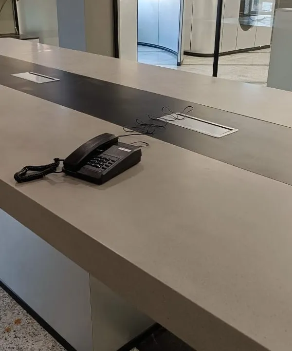 An intercom phone placed on a large conference table. Our EPABX systems ensure that every key point in your office has a reliable communication line.