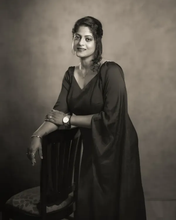 This black and white portrait of Vidyasri has a classic, timeless feel. The monochrome treatment emphasizes her confident pose and the elegant lines of her dress, creating an image of strength and grace that could have been taken in any era.