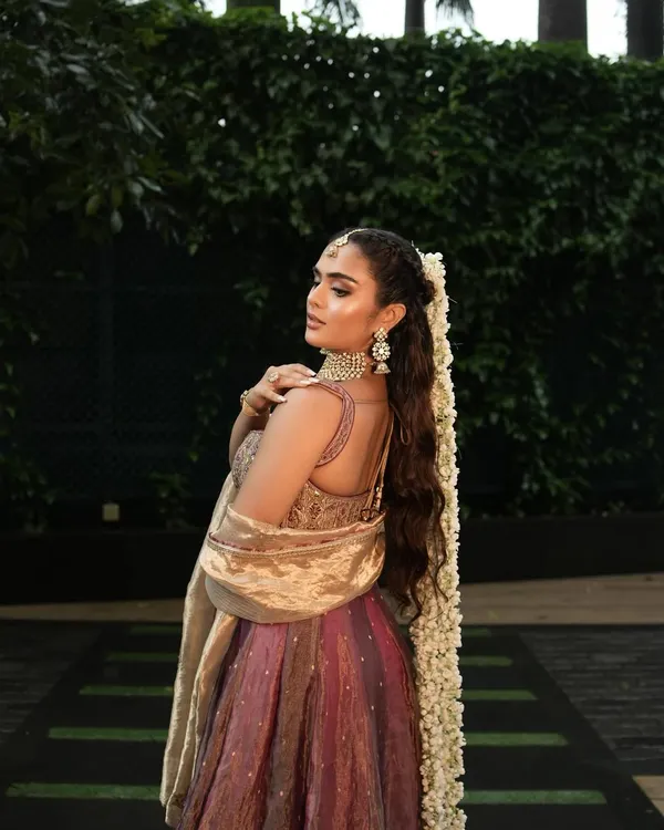 A perfect Mehendi look isn't complete without the right hairstyle. This long, wavy ponytail adorned with a gajra is elegant, comfortable, and keeps the hair off the face during the ceremony.
