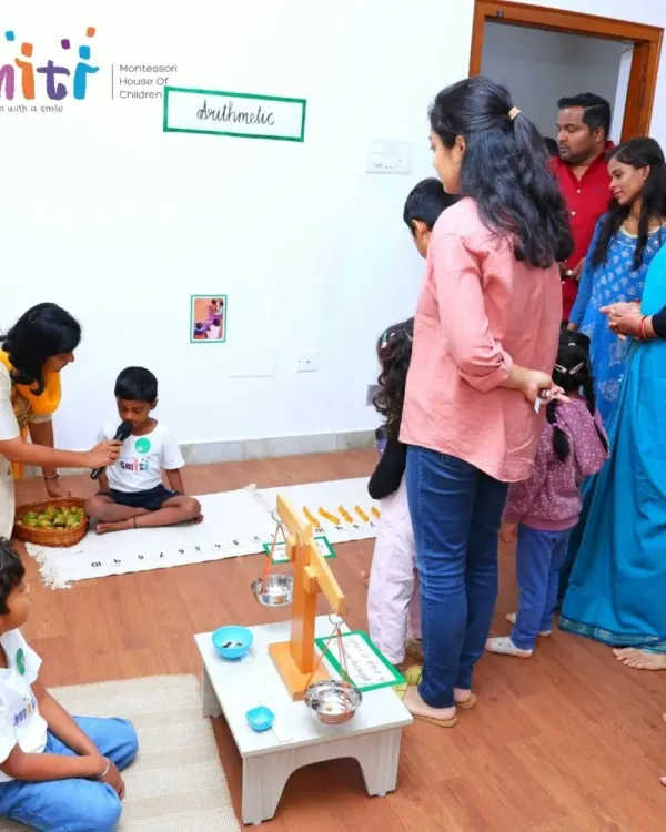 Parents and grandparents listen as a child explains a Montessori arithmetic material during our "Coconut Chronicles" science fest. We love creating opportunities for children to share their learning with family.