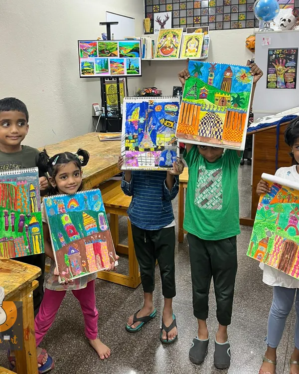 We believe creativity blooms when kids work together. Here, a group of our young artists, aged 6 to 8, proudly display the vibrant cityscapes they created, each piece a unique story of color, imagination, and teamwork.