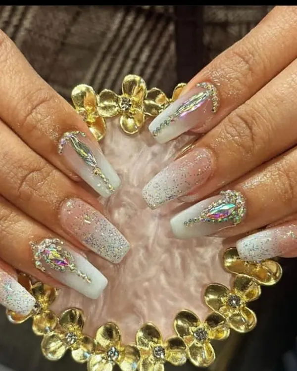 Intricate nail extensions featuring a white glitter base with large, iridescent aurora borealis crystals for a dazzling effect.