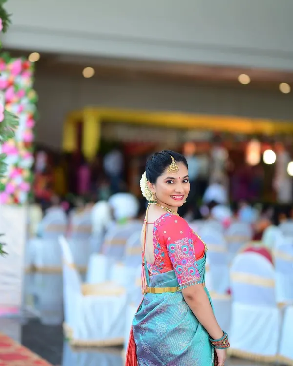A perfect look for a wedding guest. The makeup is fresh and radiant, and the simple hairstyle lets her beautiful smile and elegant saree shine.