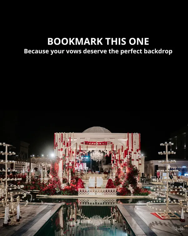 Your vows deserve the perfect backdrop. This spectacular mandap, set over a serene pool and adorned with cascading red florals and a crystal chandelier, created a dramatic and romantic setting for a night to remember.