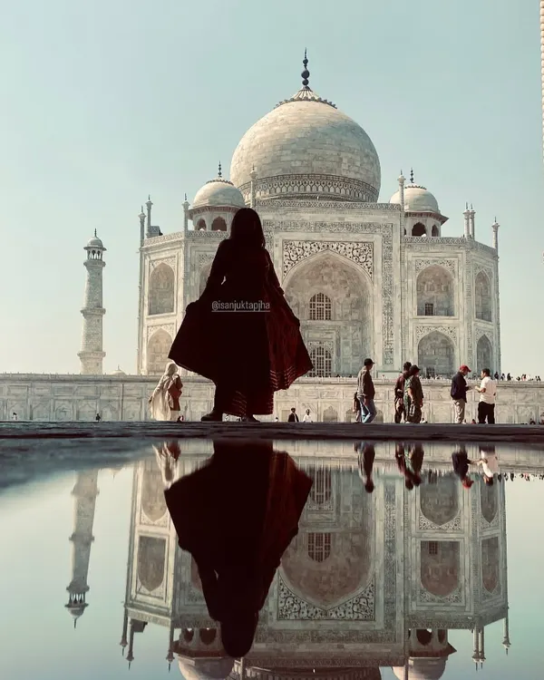 A stunning silhouette shot of me in front of the Taj Mahal with its reflection in the water. This artistic photo is a powerful piece of travel content.