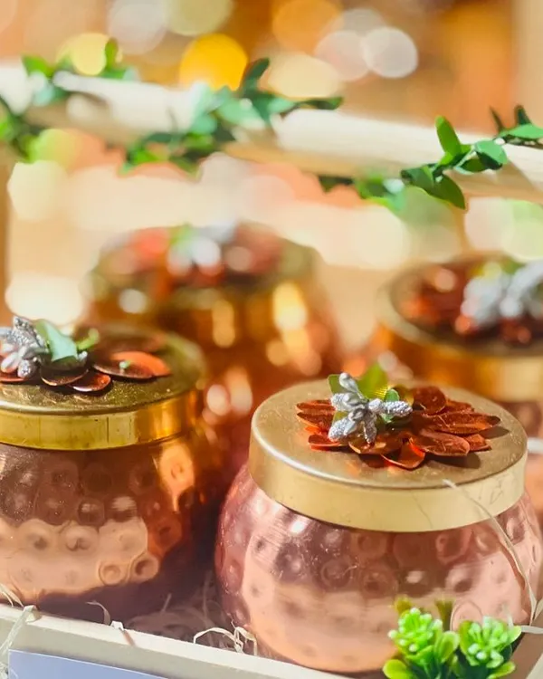 A close-up of my popular corporate gift: hammered copper jars in a wooden crate. The bokeh background highlights the premium feel of these gifts, perfect for employee appreciation or client thank yous.