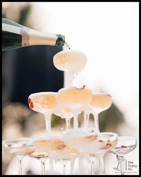 The perfect champagne pour. This close-up shot captures the moment a champagne tower comes to life, with bubbly overflowing into a cascade of celebration.