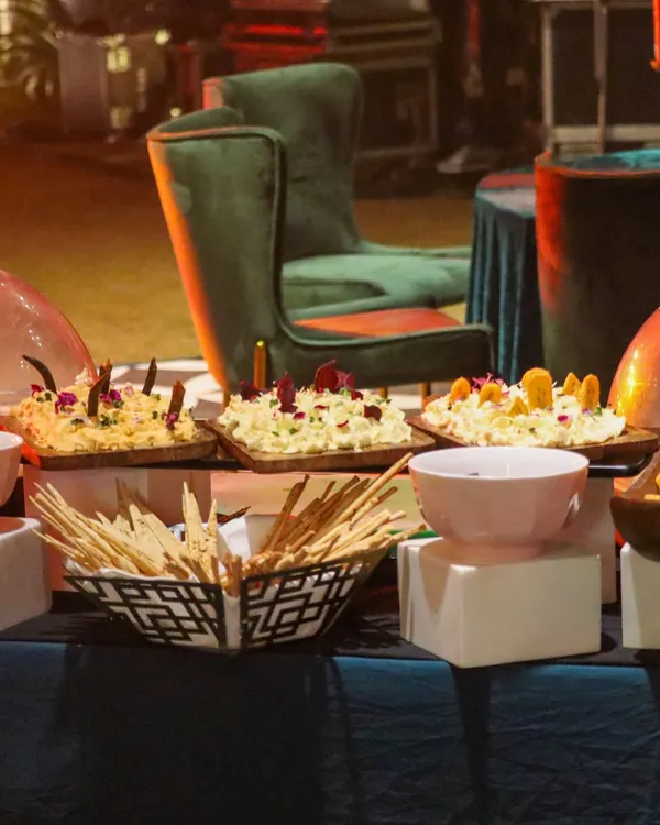 A glimpse of our buffet setup, featuring a variety of dips and breads. The presentation is rustic yet elegant, with wooden boards and stylish bowls, set against a backdrop of luxurious event furniture.