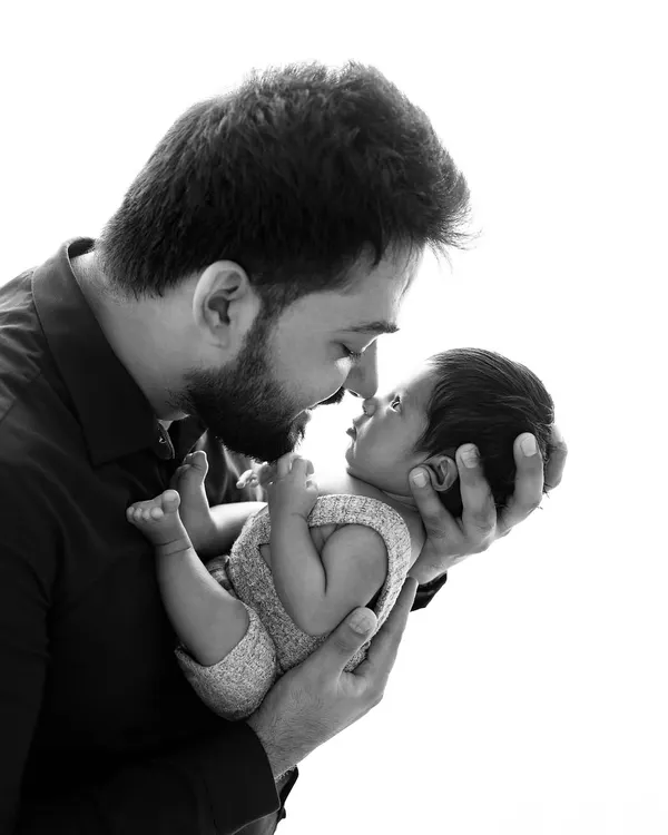 A powerful black and white portrait of a father and newborn. Removing color puts all the focus on the emotional connection and the tender way he holds his baby.