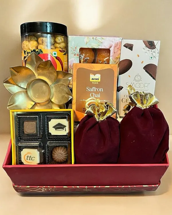 This beautiful Diwali tray is filled with festive delights, including custom-branded chocolates, saffron chai, gourmet popcorn, and a decorative tea light holder.