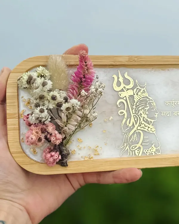 ॐ नमः शिवाय. This is one of my favorite pieces, a decorative wooden tray with a resin art inlay. It features a golden Shiva trishul, dried flowers, and a sacred mantra. It's perfect for your home temple or as a thoughtful gift.