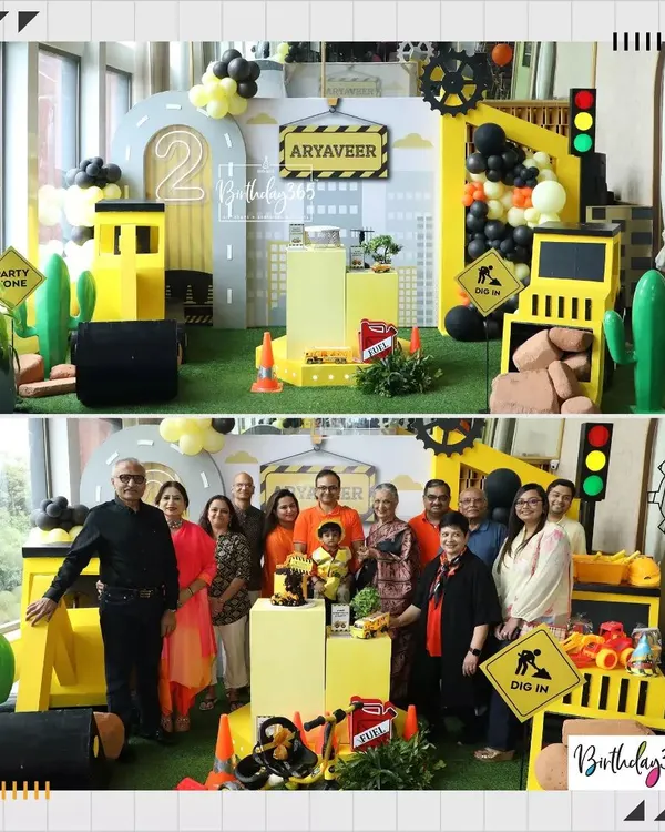 A full view of our construction-themed party for Aryaveer's 2nd birthday. The setup includes a city skyline backdrop, custom props, and a fun "Dig In" sign, with the family posing for a photo.