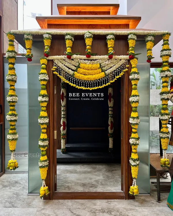 Traditional decor is our all-time favorite. This beautifully decorated pooja room entrance features intricate 'thomala' made from fresh flowers, creating a sacred and welcoming feel for a housewarming ceremony.