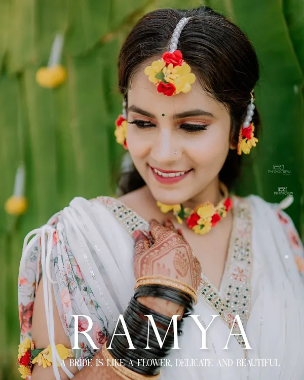 A beautiful close-up of the bride during her Haldi ceremony, adorned with fresh floral jewelry. We focus on capturing the bridal glow and intricate details.