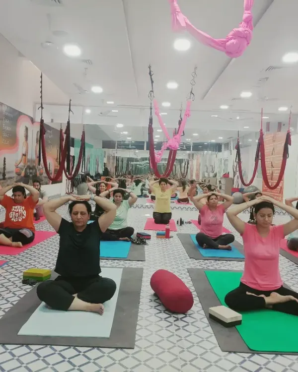 A group of students practicing pranayama (yogic breathing). This practice is fundamental for calming the nervous system, improving focus, and preparing the body and mind for meditation.