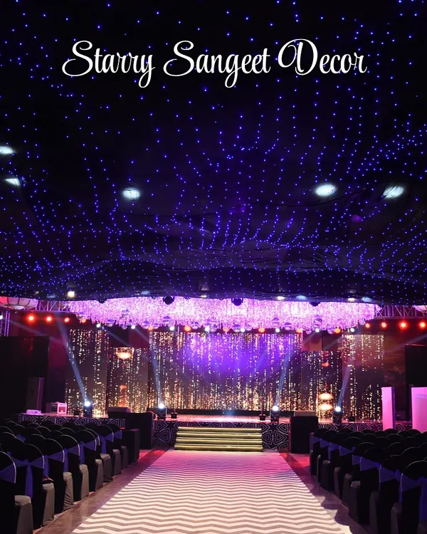 A ceiling of twinkling fairy lights creates a 'starry night' effect for this Sangeet. This immersive lighting design transforms the entire ballroom into a magical, celestial space for a night of dancing and celebration.