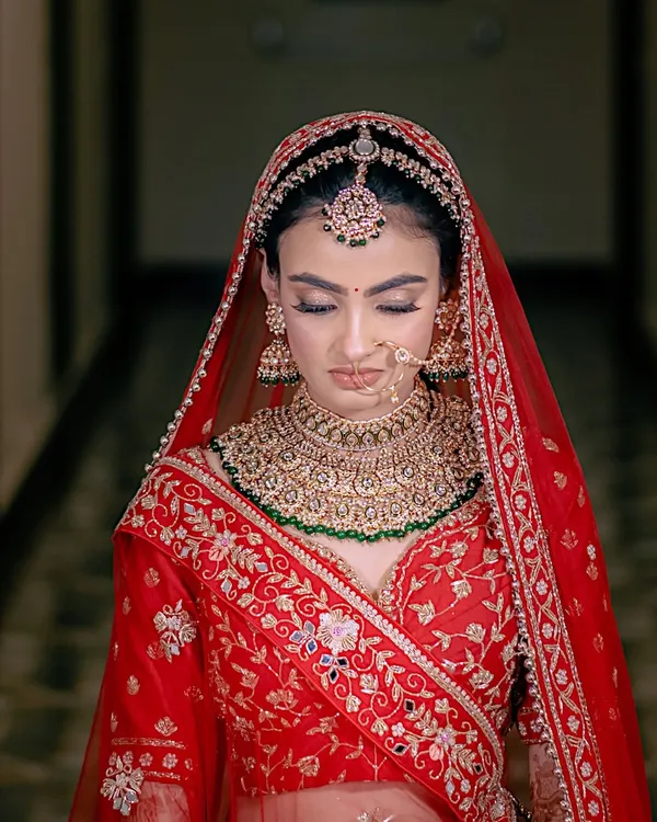 A portrait of bridal elegance. The focus on the intricate jewelry and serene expression captures the moments of quiet anticipation before the ceremony.