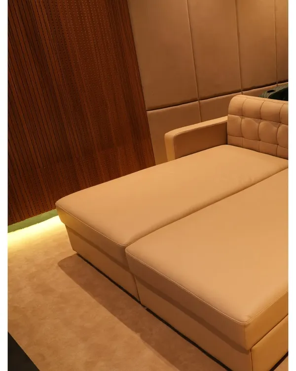 A close-up of a custom-designed daybed in a Nellore project, showing the combination of plush upholstery and elegant wood paneling with subtle floor lighting.