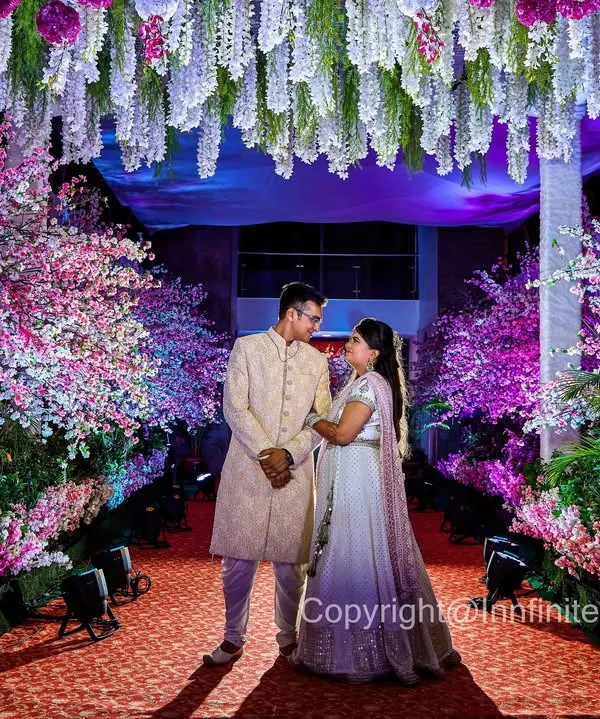This engagement portrait uses the magnificent floral decor to create a grand, fairytale-like setting. The dramatic lighting makes the couple stand out beautifully.