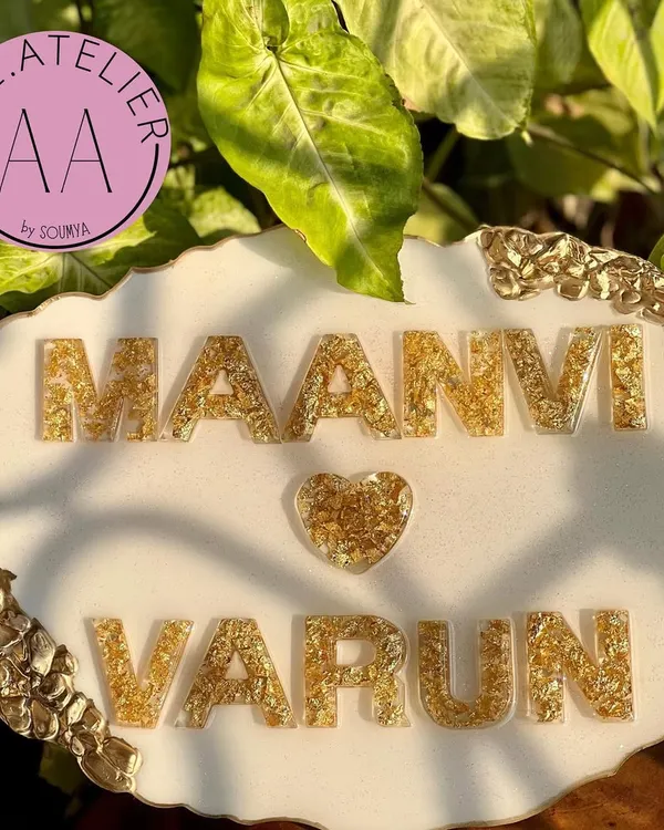 A close-up of the beautiful gold foil lettering on a white and gold geode nameplate for Maanvi and Varun. Every detail is crafted with so much pyar.