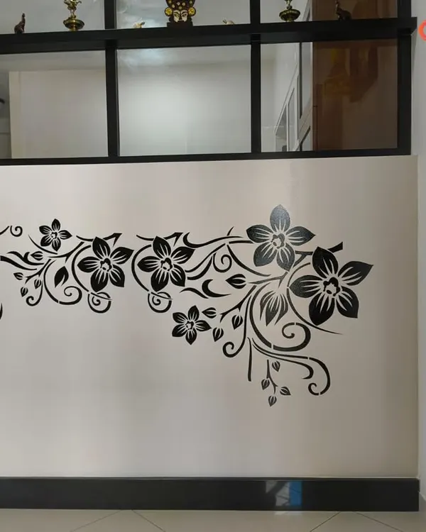 A classic and elegant floral vine stencil in black, applied to a light-colored wall. This type of design works beautifully in hallways or living rooms to add a touch of sophisticated decoration.