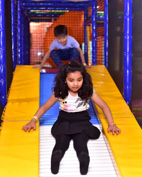 A young girl enjoys a fast ride down one of our roller slides. This slide provides a unique sensory experience with its rolling bars.