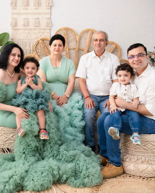 A beautiful portrait of three generations. This photo captures the entire family, including grandparents, in a coordinated and elegant setting, creating a priceless family heirloom.