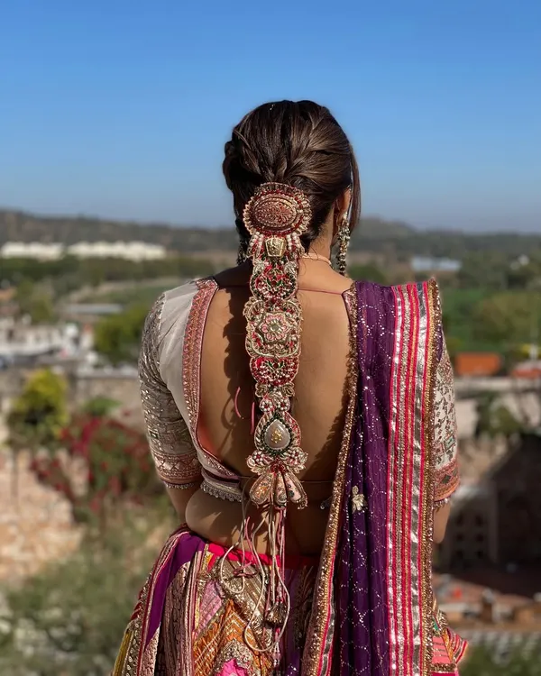 For this Mehndi look, I designed an intricate statement braid and adorned it with a stunning, oversized traditional hair accessory. This style is not only beautiful from the back but also practical for a long event.