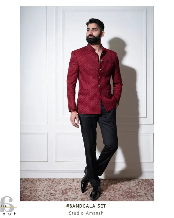 A full-length view of our crimson bandhgala set. The jacket's textured fabric and clean lines create a powerful statement, paired here with classic black trousers for a balanced and sophisticated formal look.